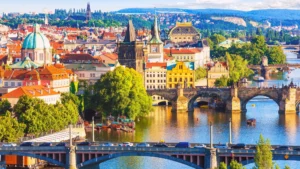 A vista in Prague showcases two bridges spanning the Vltava River, with awe-inspiring historical structures forming the background.