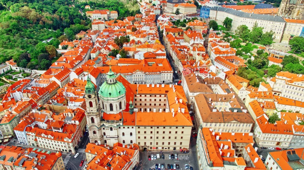 Ariel view of Prague's Lesser Town, its terracotta roofs, copper church copulas and surrounding parks.